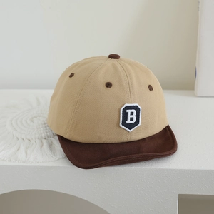 Detailed macro view of khaki cotton baby baseball cap with blue letter B embroidery