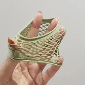 Élastique à cheveux vert clair avec texture en nid d'abeille étiré pour montrer sa résistance