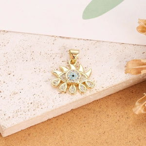 Detailed view of a gold-plated evil eye pendant with blue and clear zircon stones