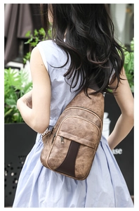 Brown vintage PU leather crossbody chest bag shown on model in a stylish street setting