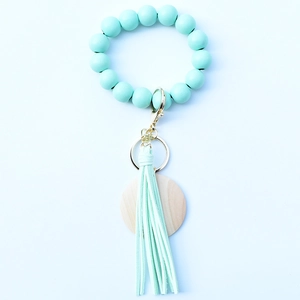 Beaded keychain bracelet with mint green wooden beads, leather tassel and metal clasp
