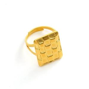 Macro detail of gold geometric ring featuring a textured square top and open band design