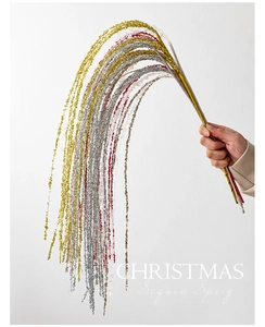 Close-up of sparkling sequin Christmas sprigs in gold, silver and red for festive decor