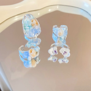 Detailed mirror view of shell beads and floral open rings with elegant silver finish
