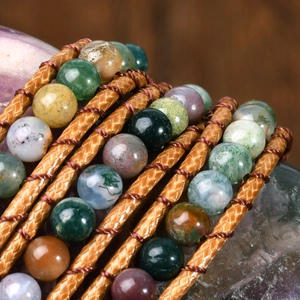 Macro detail of handmade Indian agate beads on multi-layer braided brown leather wrap bracelet