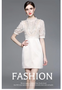 Detail view of the intricate white lace embroidery and heavy beadwork on the bodice