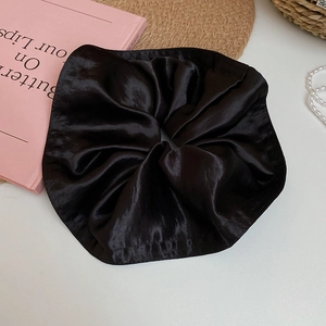Close-up of black satin oversized scrunchie on a French aesthetic vanity tabletop