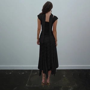 Vue détaillée du dos d'une robe noire en dentelle avec lacets et rubans flottants