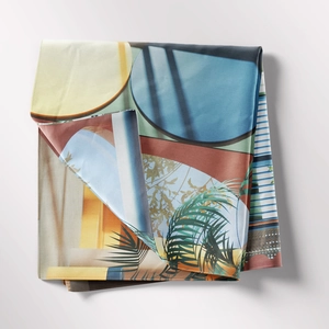 Detailed view of bohemian tapestry fabric with geometric patterns and tropical palm leaves