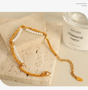 Close-up of double-layer gold pearl bracelet on stone base with adjustable chain detail