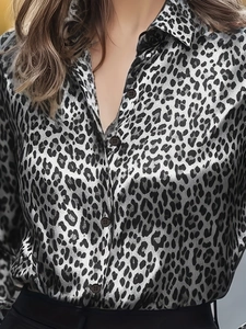 Detail of leopard print long sleeve shirt showing fabric texture and button closure