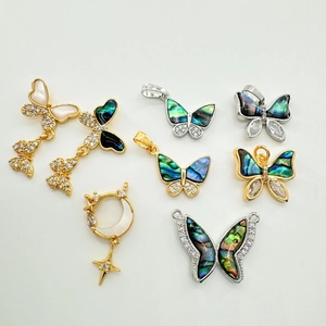 Vue macro de pendentifs papillon en nacre dorés 18K avec micro-incrustation de zircons