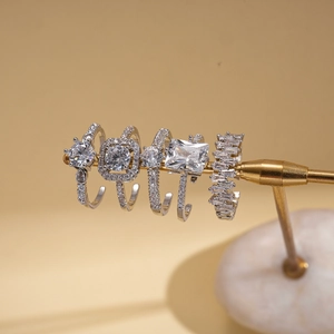 Detail of five silver rings featuring zircon stones in square and round cuts