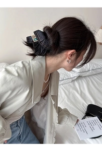 Close-up of denim scrunchie with vintage label and detailed stitching on model