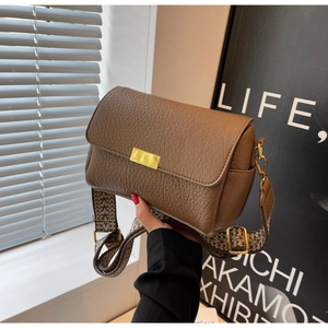 Détail d'un sac marron avec cuir grainé et bandoulière large en jacquard rétro