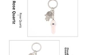 Detailed macro view of natural hexagonal rose quartz crystal with silver Hamsa hand charm