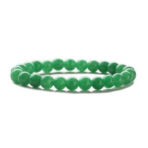 Close-up of green tiger eye beaded elastic bracelet with smooth polished crystal texture
