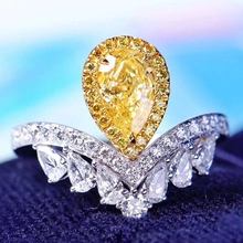 Macro shot of V-shaped crown ring with pear-cut yellow gemstone and white zirconias