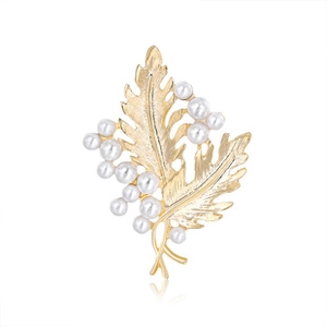 Macro shot of gold leaf brooch with white pearls and sparkling diamond wheat ear detail