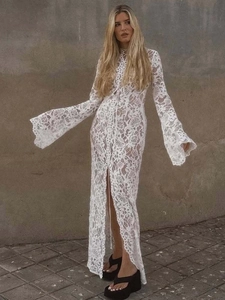 Elegante abito lungo in pizzo bianco con maniche lunghe a campana e spacco alto sexy