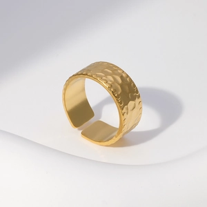 Detailed view of gold stainless steel open ring with unique hammered metal texture finish
