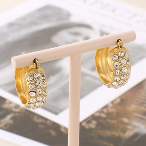 Elegant gold-plated hoop earrings with rows of clear rhinestones on a pink display stand