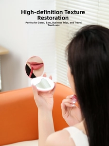 Close-up of portable LED makeup mirror in pink being used for lipstick touch-ups