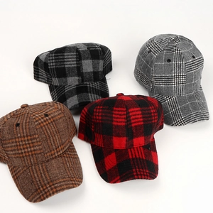 Flat lay of multiple plaid wool baseball caps in brown and red for autumn and winter