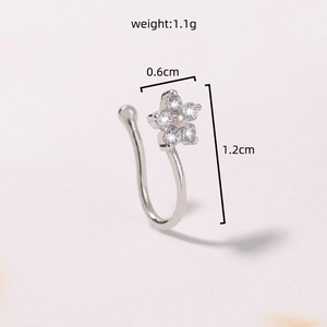 Macro detail of star flower nose stud in silver steel with white cubic zirconia gems