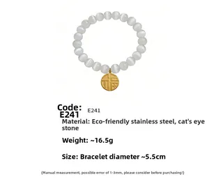 Detail of white cat eye stone bead bracelet featuring a gold Fu charm and steel components