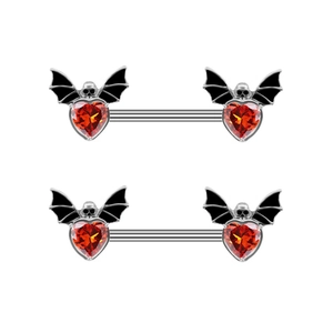 Macro shot of gothic nipple rings with red heart gems, bat wings, and skull details