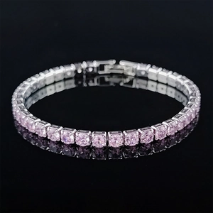 Macro shot of silver tennis bracelet featuring round pink zircons and a secure fold-over clasp