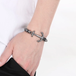Detail of vintage anchor bracelet in distressed silver with skull links on male wrist