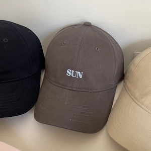 Close-up of SUN embroidery on cotton baseball caps in black, brown, and beige colors