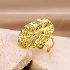 Macro detail of a hammered gold statement ring with lava texture and adjustable band