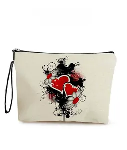 Detail of canvas makeup bag featuring red heart and black floral print with black wrist strap