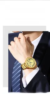 Detail of gold mechanical watch with crystal bezel and Roman numerals on male wrist