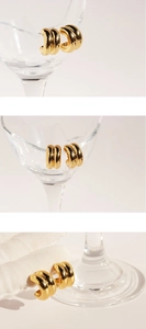 Macro shot of minimalist triple-layered gold hoop earrings with polished mirror finish