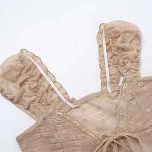Detail of apricot lace mesh camisole with ruffled straps and intricate hollow embroidery