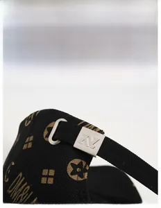Detailed view of the adjustable silver metal buckle with engraved AV logo on a black cap