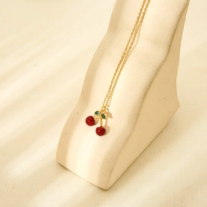 18K gold plated stainless steel necklace with 3D red cherry enamel pendant on beige stand