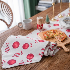 Festive Christmas table runner with red ornaments and bells on rustic wooden table