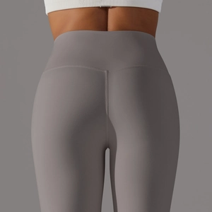 Gros plan sur le legging de yoga gris taille haute montrant l'effet galbant