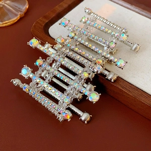 Detail of silver metal hair clips with AB crystal rhinestones on a linen tray