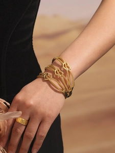 Gros plan de bracelets cœur dorés à double ligne avec perles texturées au poignet