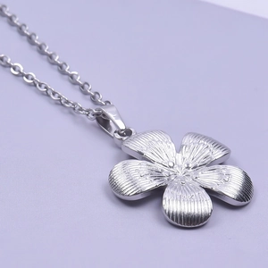 Close-up of a silver five-petal flower pendant on a polished stainless steel chain