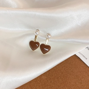 Détail de boucles d'oreilles papillon géométriques avec cœurs marrons et perles sur soie