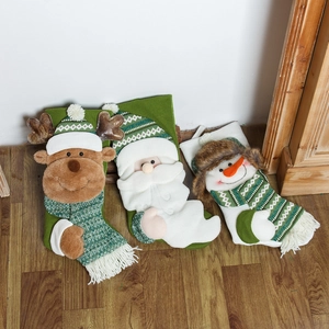 Three knit Christmas stockings with reindeer, Santa, and snowman figures on wood background