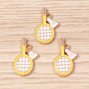 Détails des pendentifs de raquette de badminton jaune et volant sur fond de bois