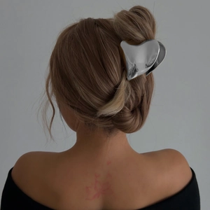 Elegant silver heart-shaped metal hair claw clip for women in a stylish updo hairstyle